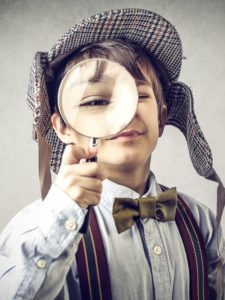 Young Sherlock with magnifying glass full picture - The Lost Money Detectives